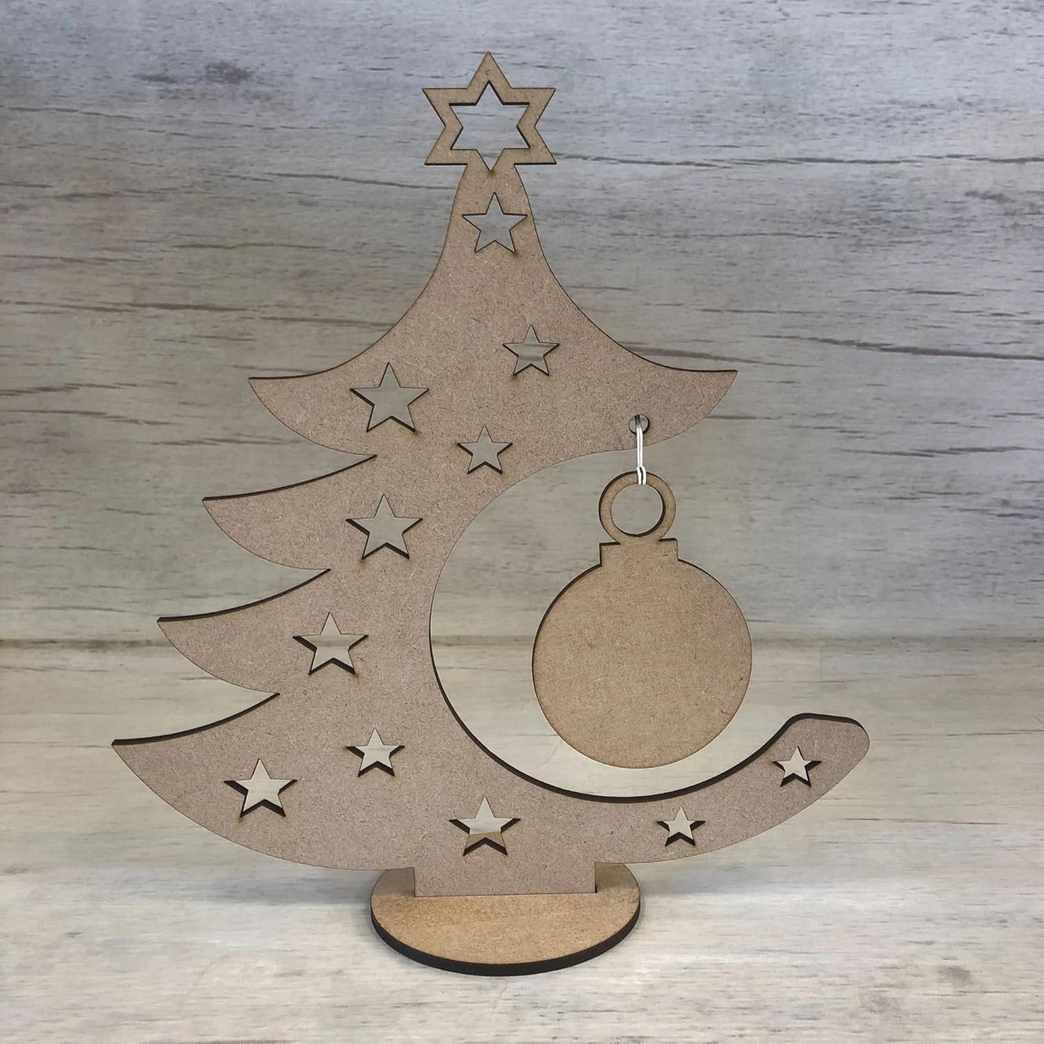 Wooden Christmas tree decoration with stars and a ball on a wooden background