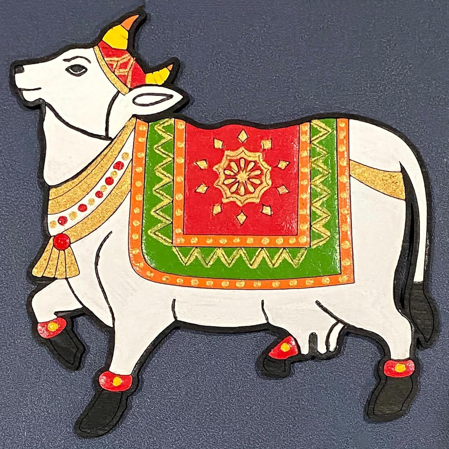 Decorative cow figure with colorful patterns on a dark background