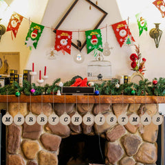 Decorated fireplace with Christmas decorations, including a 'Merry Christmas' banner.