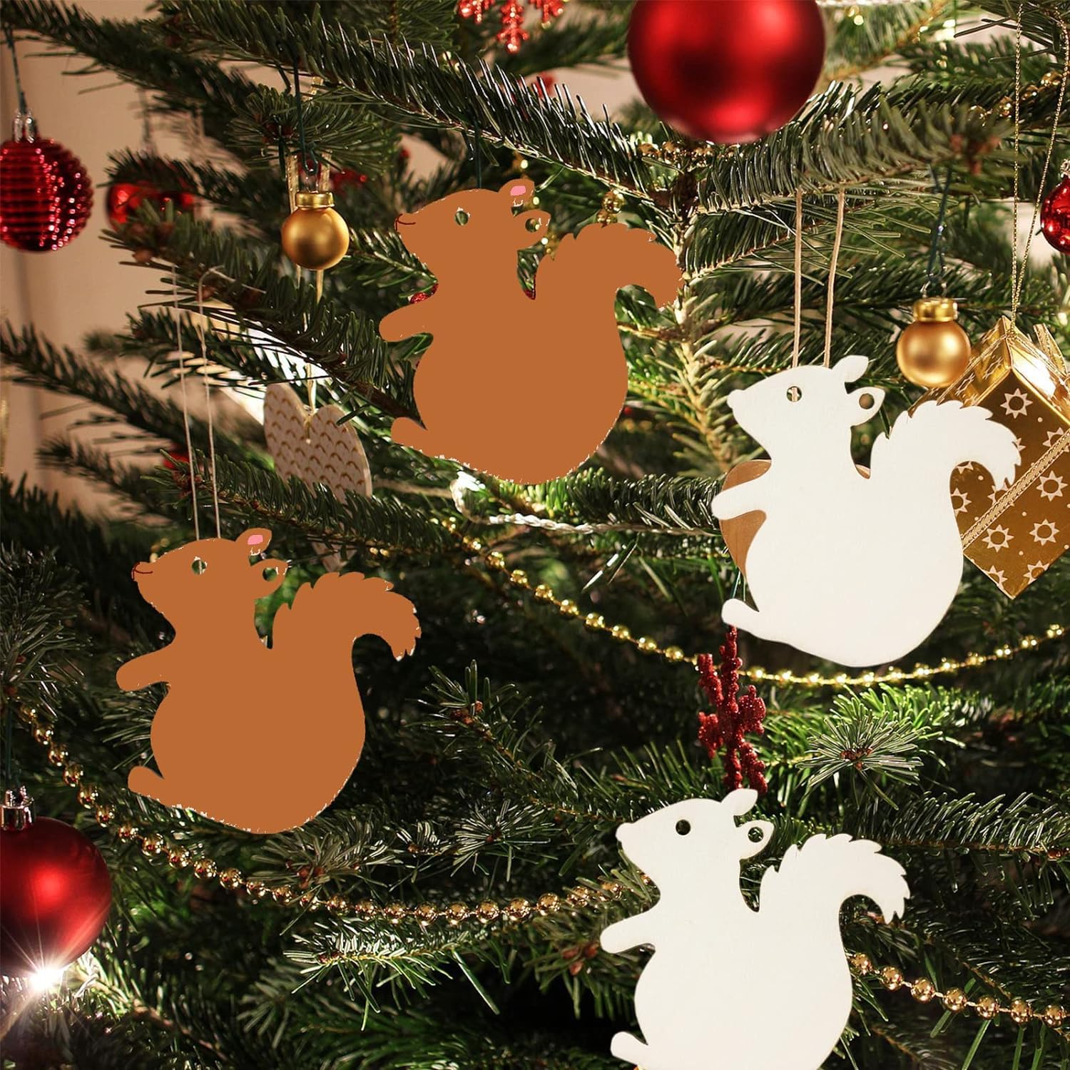 Decorative Christmas ornaments shaped like squirrels hanging on a tree.