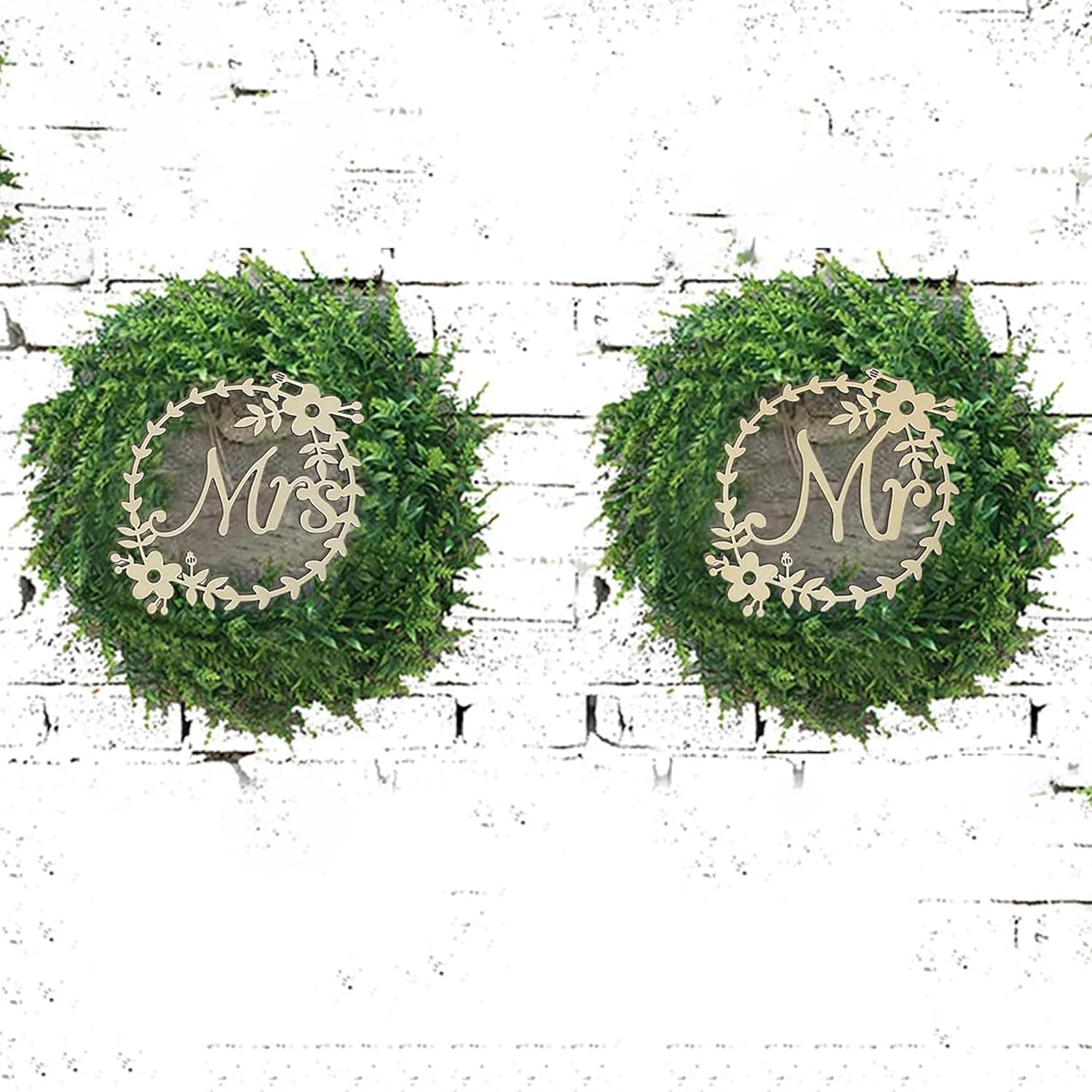 Two green wreaths with 'Mr.' and 'Mrs.' signs on a white brick wall.