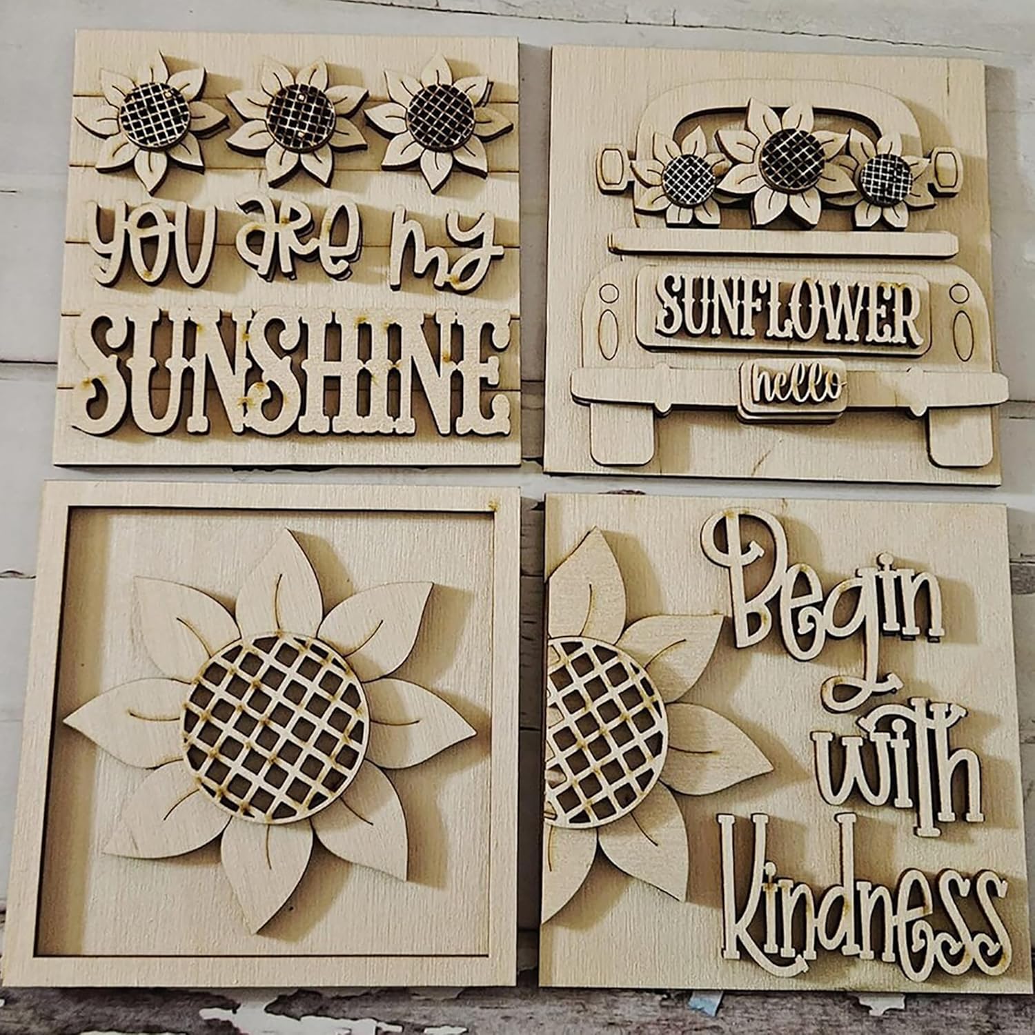 Four wooden wall art pieces with sunflower designs and text.