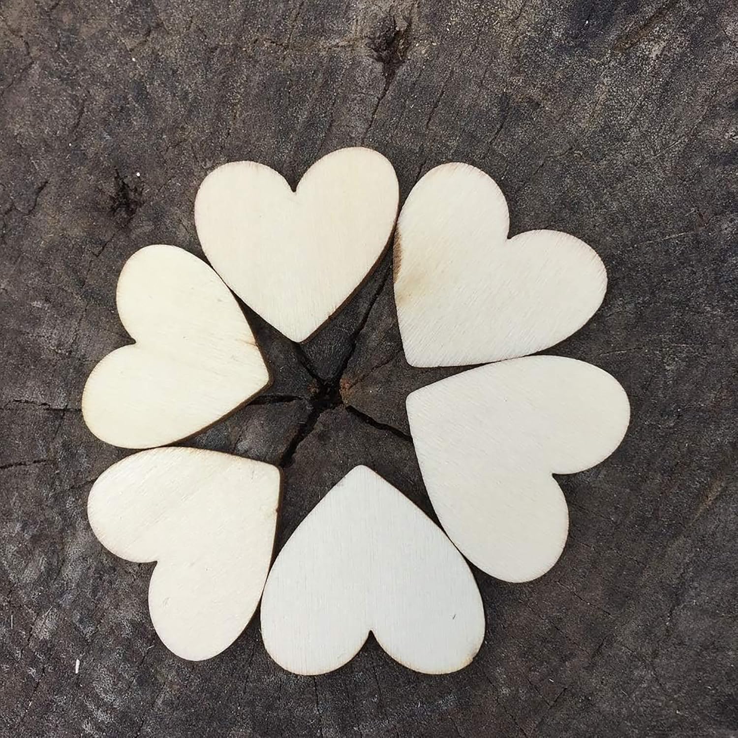 Heart-shaped stones arranged in a circular pattern on a dark surface
