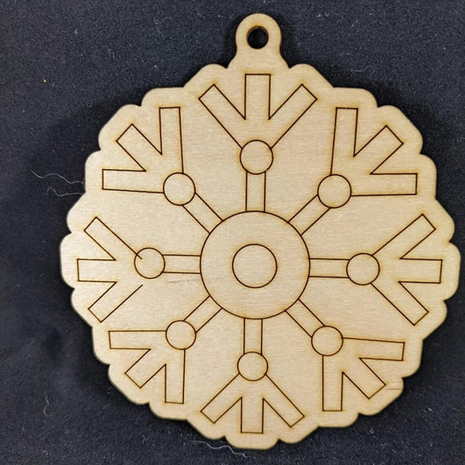 Wooden snowflake ornament on a black background