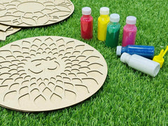 Wooden circular templates with paint bottles on grass