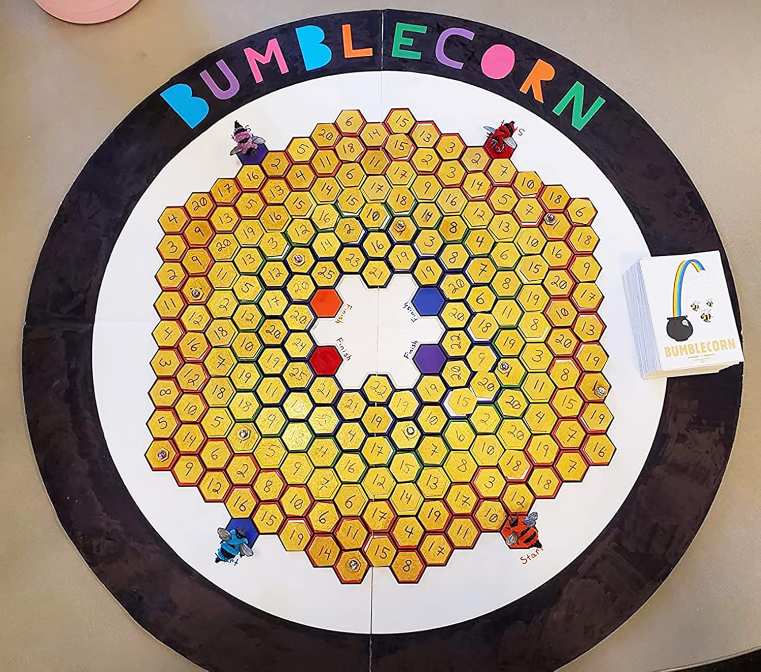 Round board game with hexagonal grid and colorful characters, branded 'Bumblecorn'.