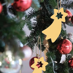 Close-up of a Christmas tree with gold star-shaped ornaments and red baubles.