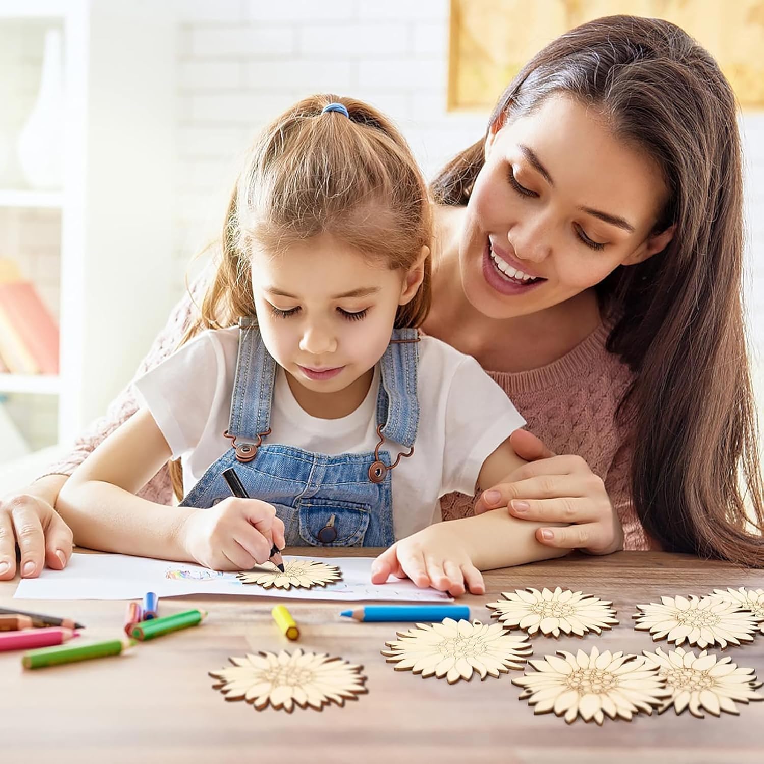 Woman and child making wooden flower crafts together on a table.