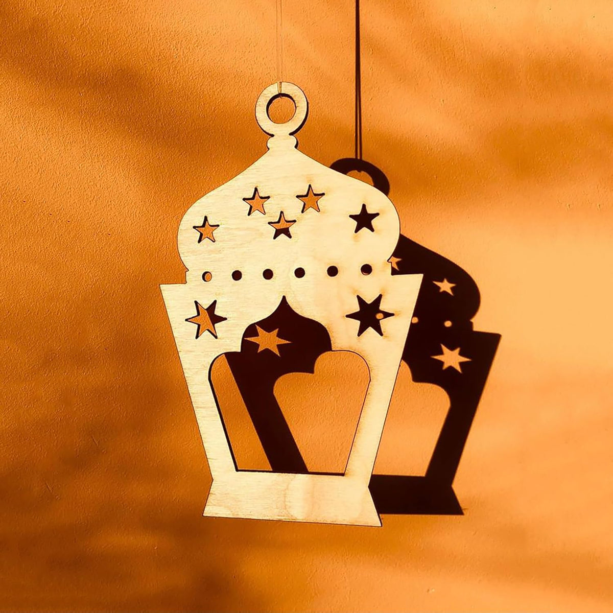 Decorative lantern ornament with star patterns on an orange background
