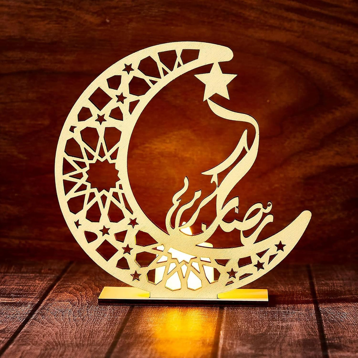 Decorative moon and star design with Arabic calligraphy on a wooden background