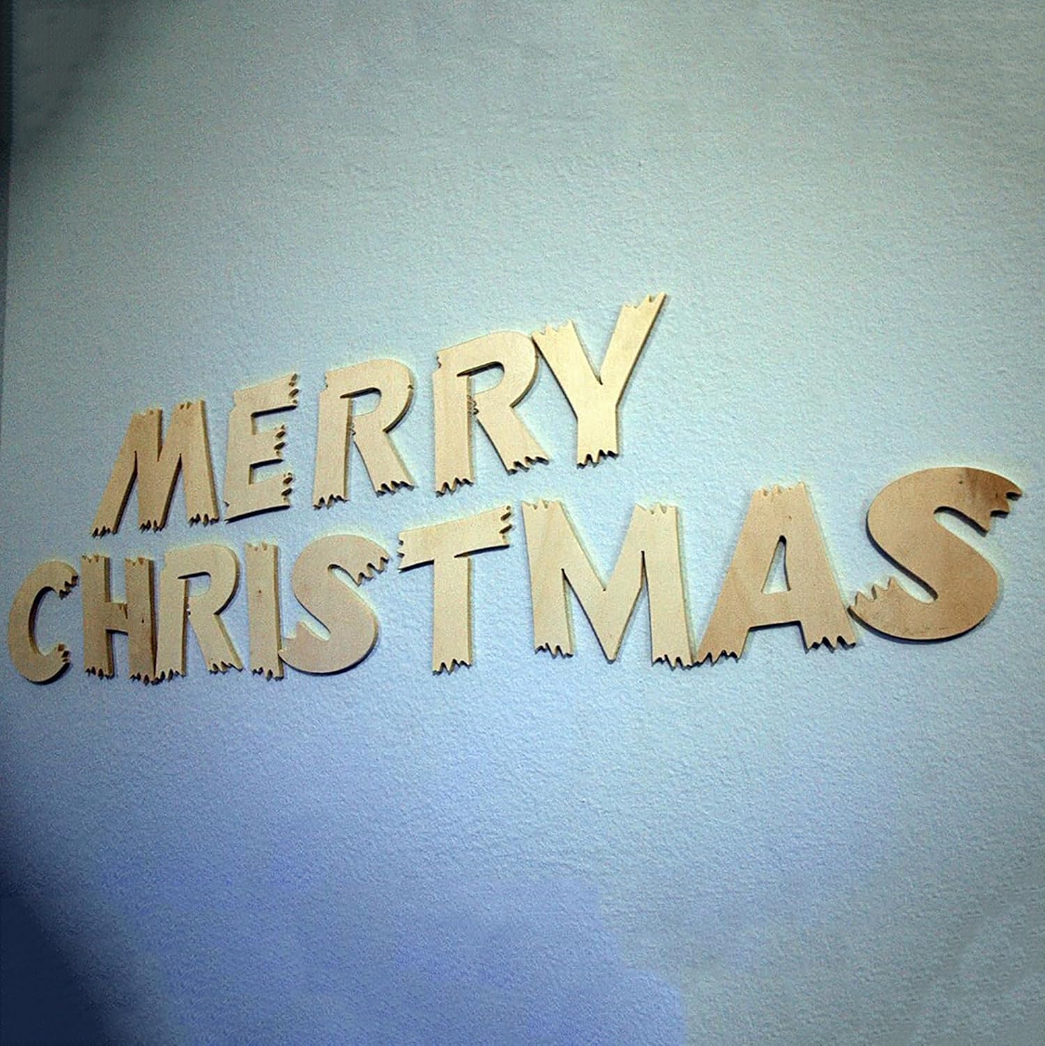 Wooden 'Merry Christmas' letters on a light blue background