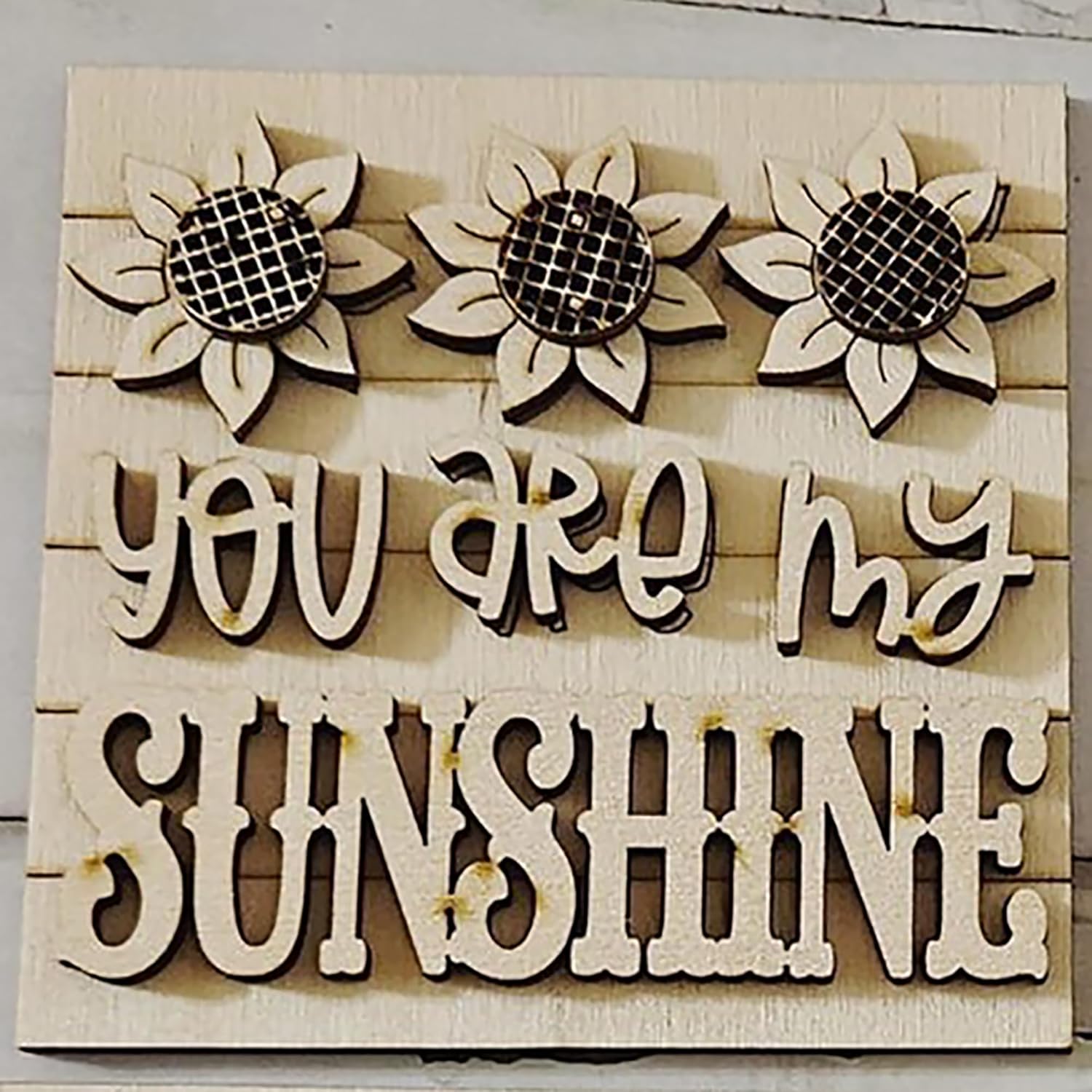 Wooden sign with sunflowers and 'You are my sunshine' text on a wooden background