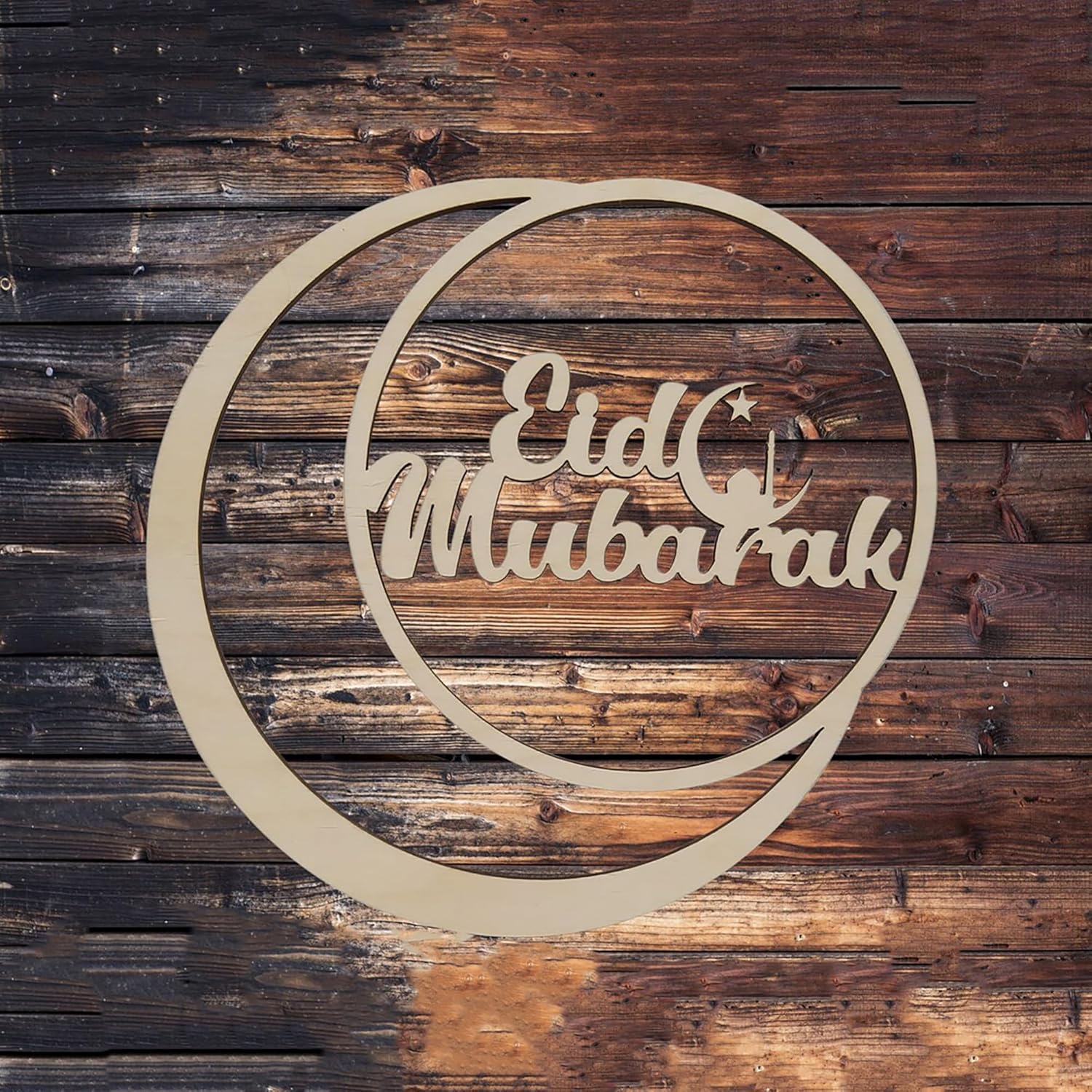 Decorative metal sign with 'Etd Mubarak' text on a wooden background