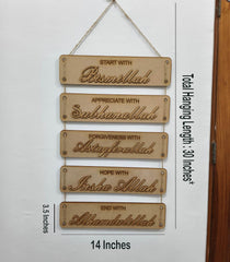 Wooden hanging sign with engraved phrases on a white wall.
