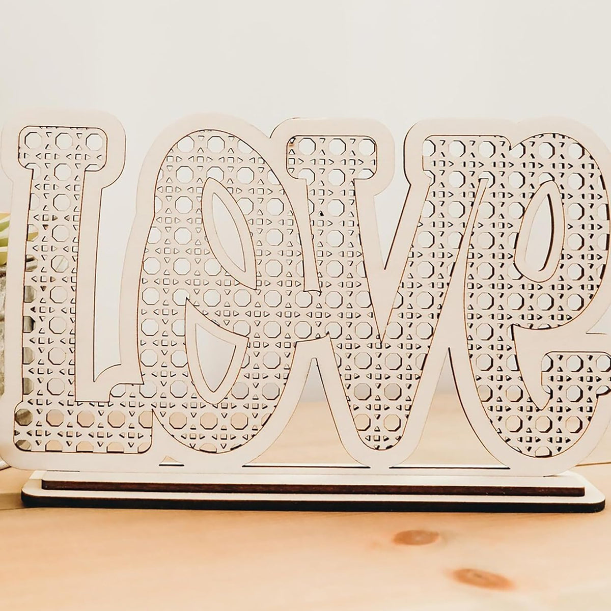 Wooden decorative sign with 'LOVE' pattern on a wooden surface