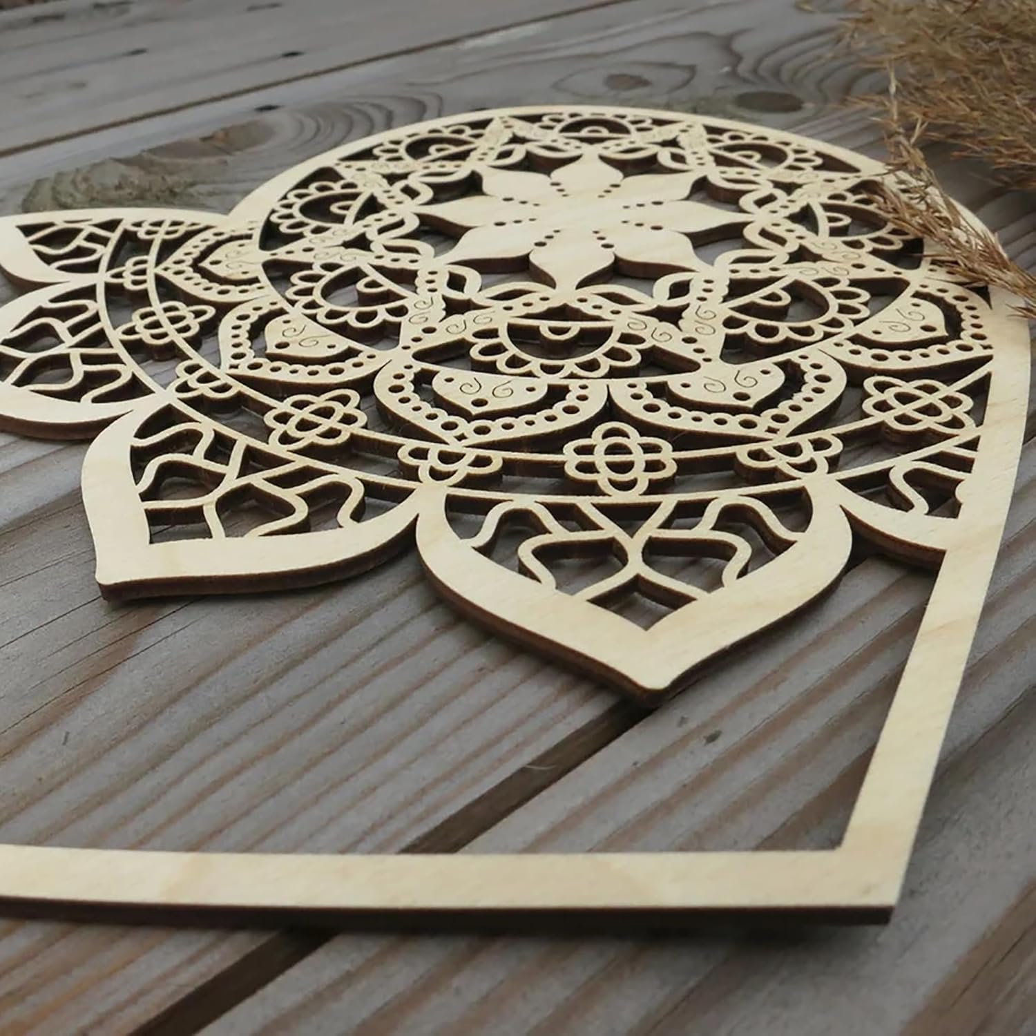 Wooden decorative panel with intricate cut-out patterns on a wooden surface