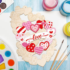 Heart-shaped wooden craft pieces with paint and brushes on a blue surface