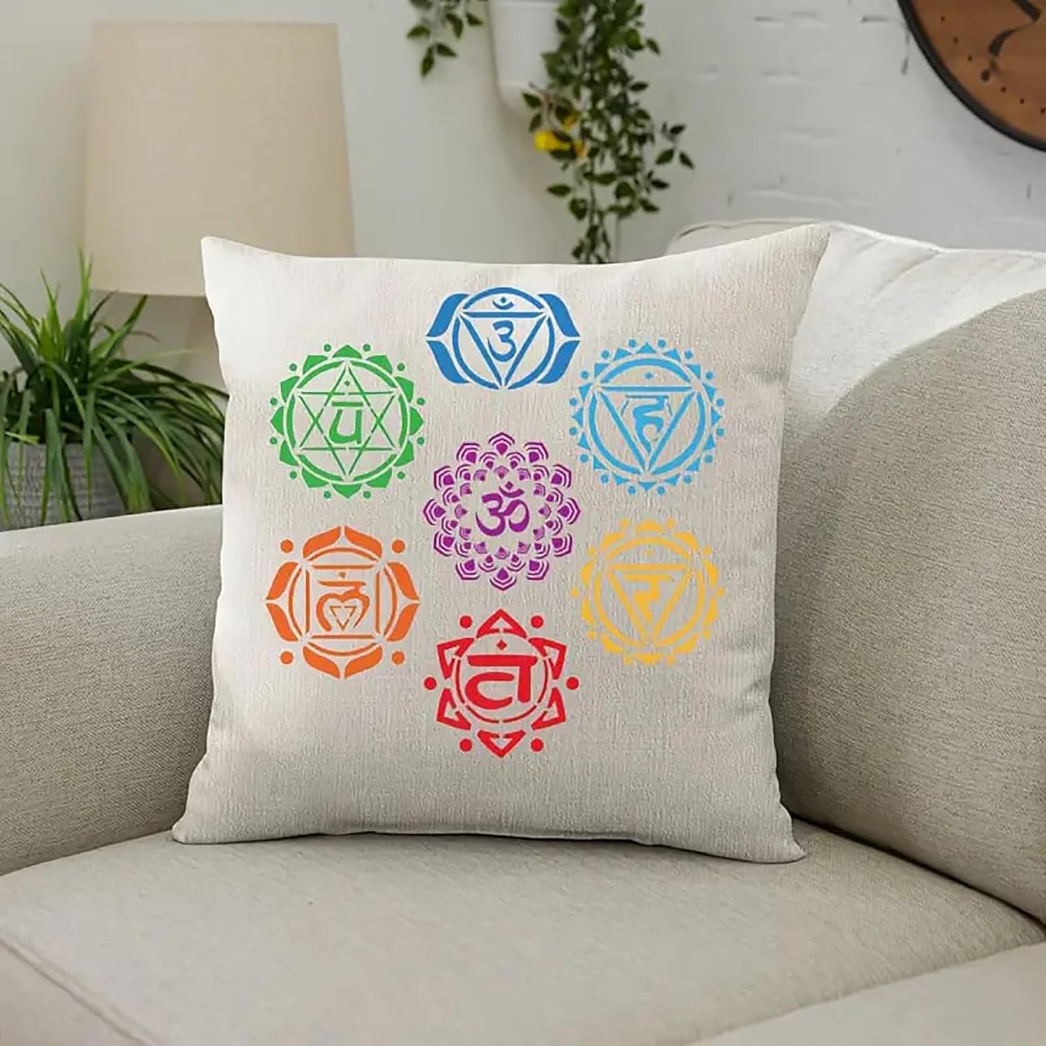 Decorative pillow with colorful chakra symbols on a beige couch.