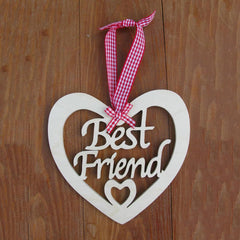 Heart-shaped wooden plaque with 'Best Friend' text and a red and white checkered ribbon on a wooden background.