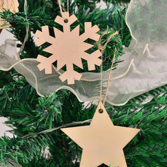 Gold snowflake and star ornaments on a Christmas tree with greenery.