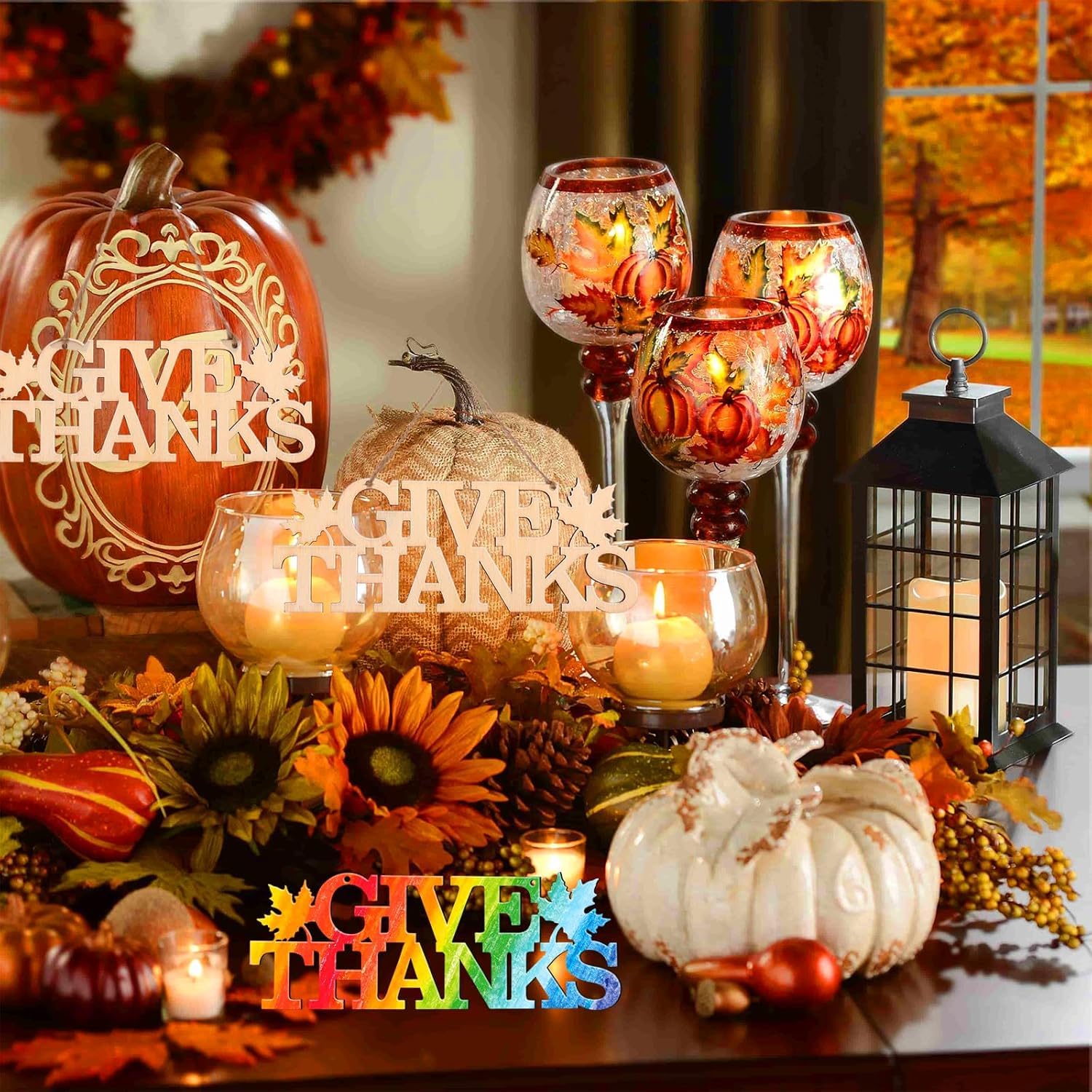Autumn-themed table setting with pumpkins, candles, and 'Give Thanks' decorations.