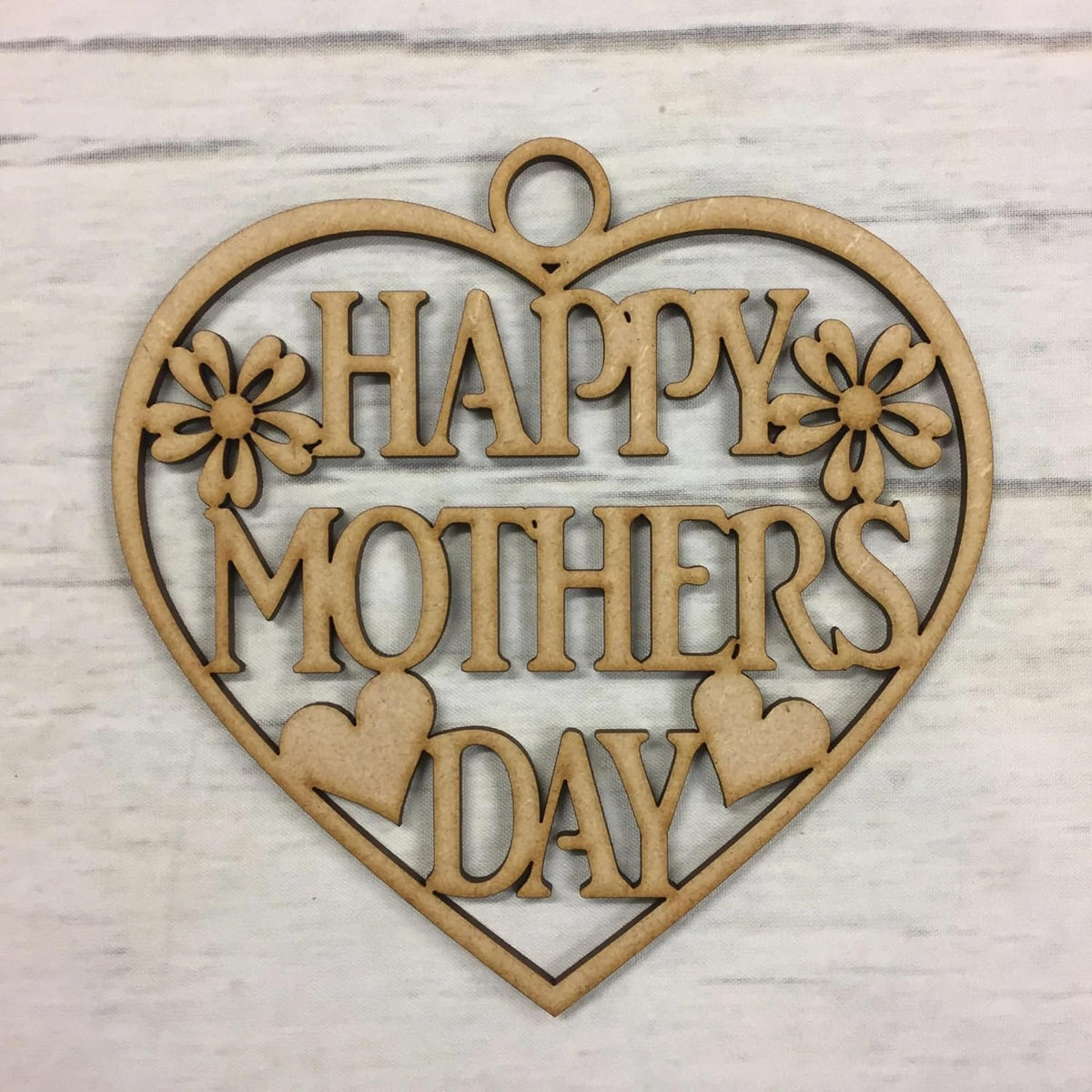 Heart-shaped wooden cutout with 'Happy Mother's Day' text on a light wood background