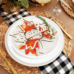 Decorative plate with 'Thankful' text and autumn leaves on a table setting.