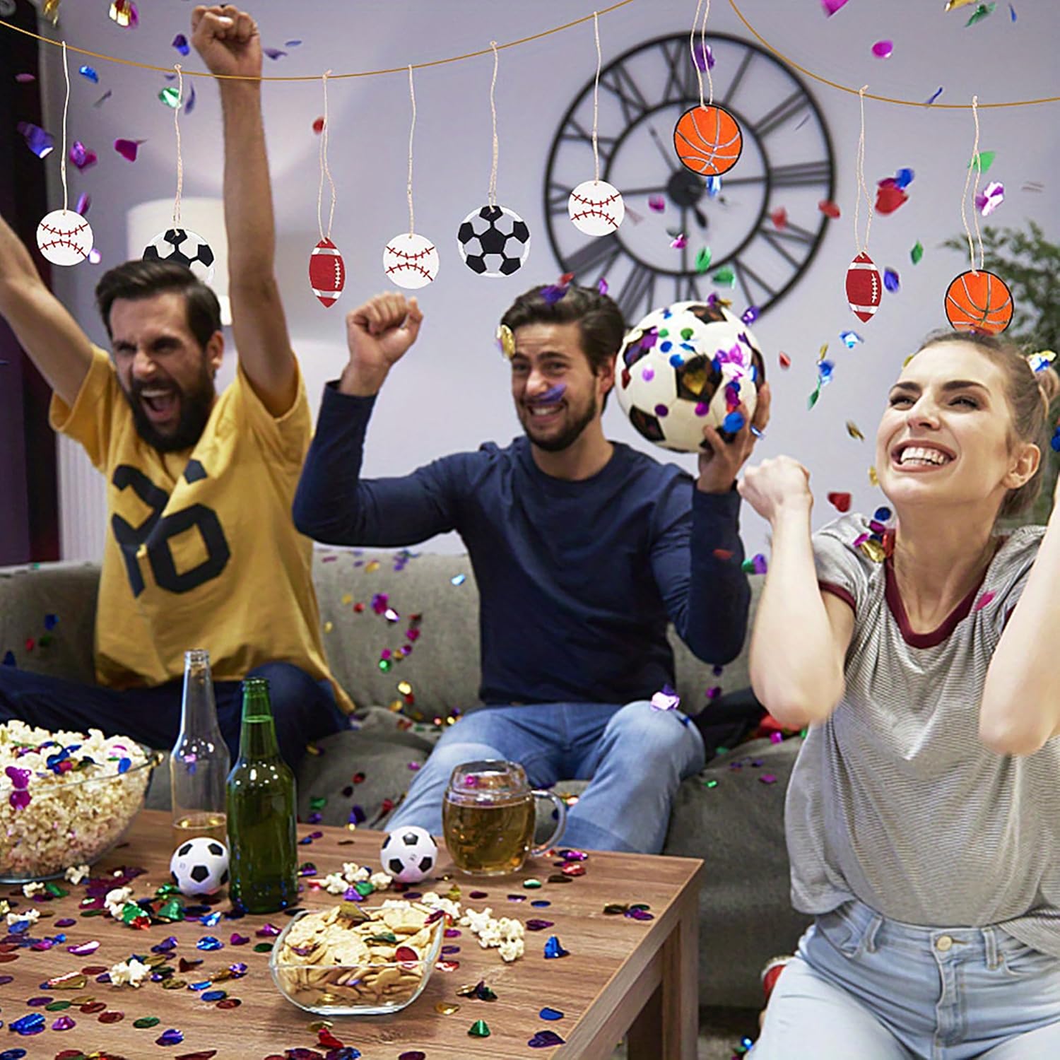 People celebrating with sports-themed decorations and snacks in a living room.