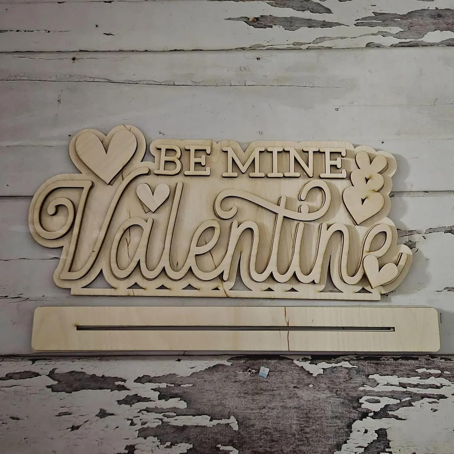 Wooden decorative sign with 'Be Mine Valentine' text on a rustic wooden background