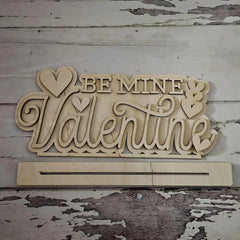 Wooden decorative sign with 'Be Mine Valentine' text on a rustic wooden background
