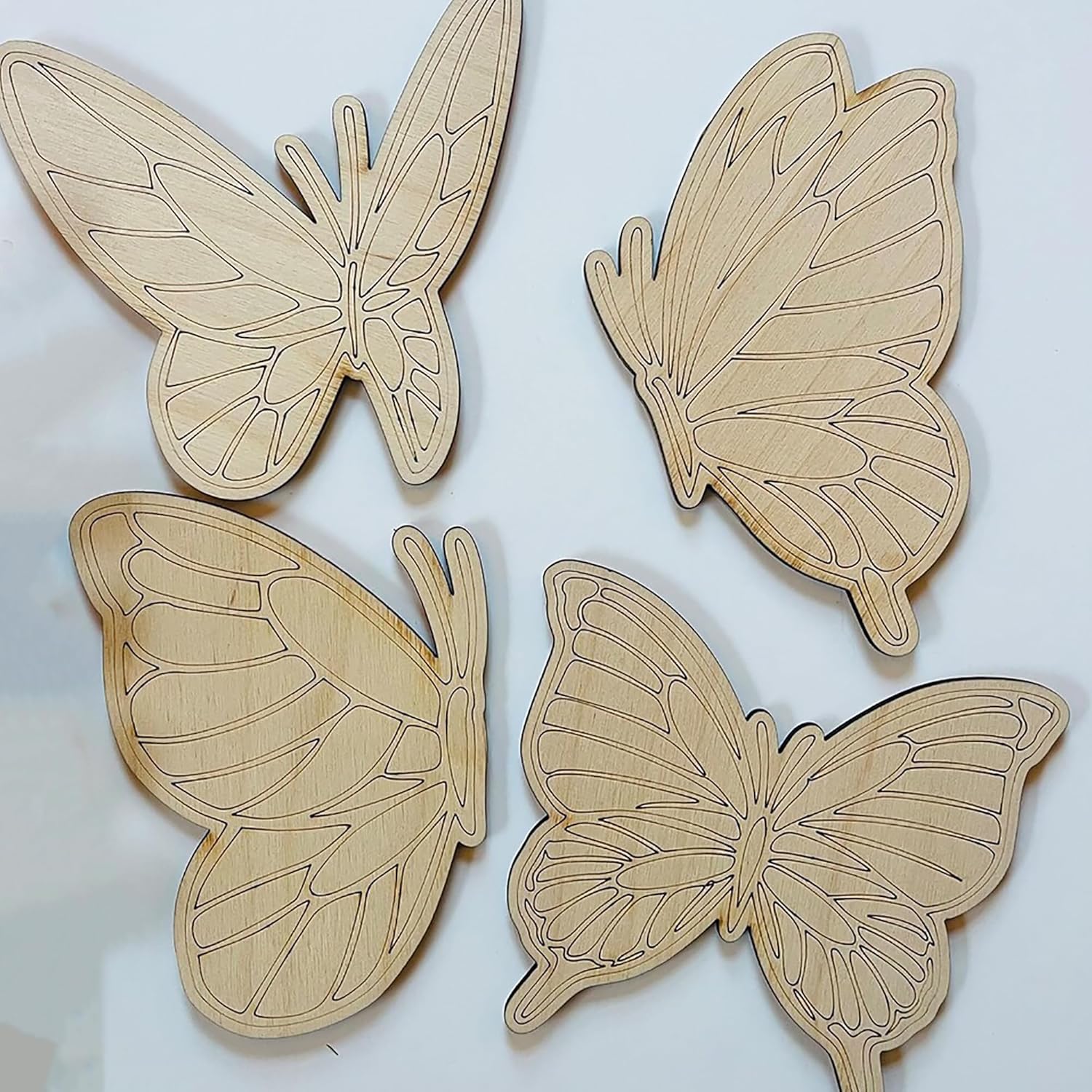 Four wooden butterfly shapes on a light background