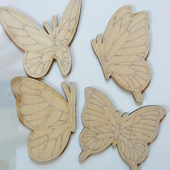 Four wooden butterfly shapes on a light background