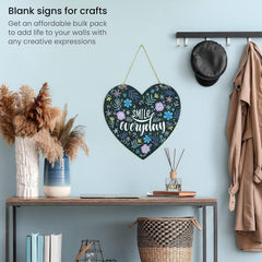 Heart-shaped decorative sign with floral patterns and text on a wall with a table and decor items.