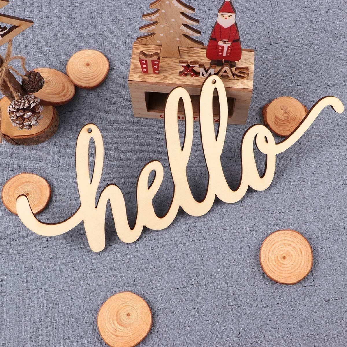 Wooden 'hello' sign with Christmas decorations on a textured surface