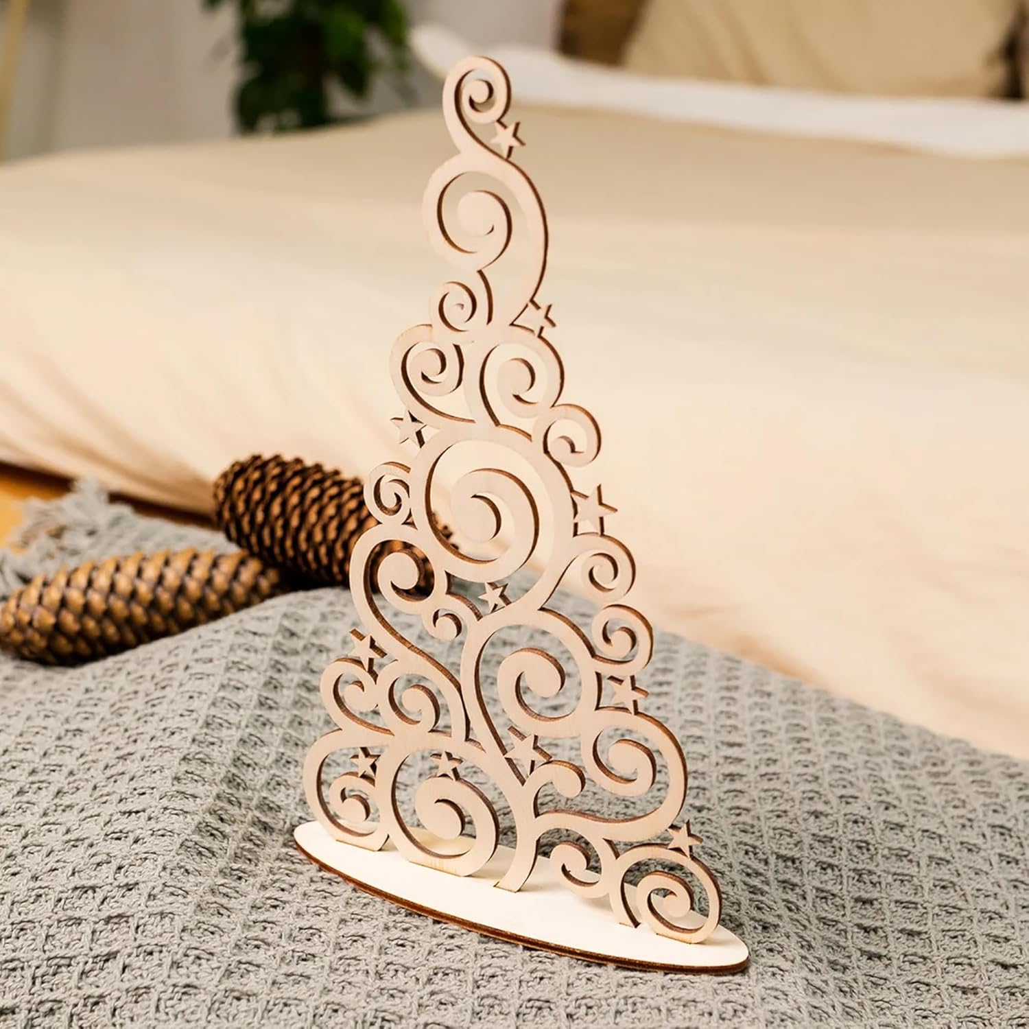 Wooden decorative Christmas tree on a textured surface with a blurred background