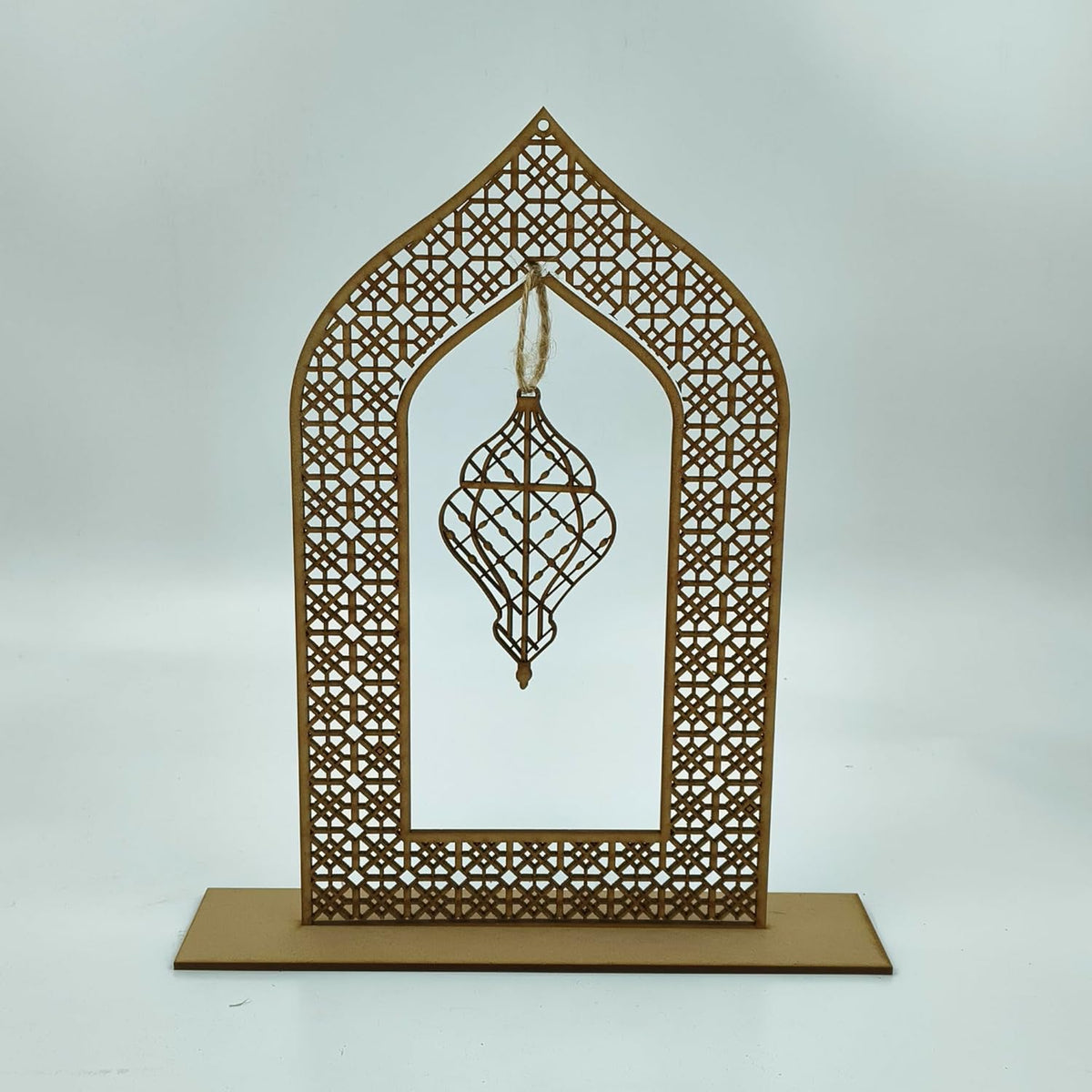 Decorative metal frame with intricate patterns and a hanging ornament on a white background