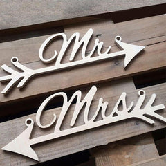 Wooden signs with 'Mr' and 'Mrs' on an arrow design on a wooden background