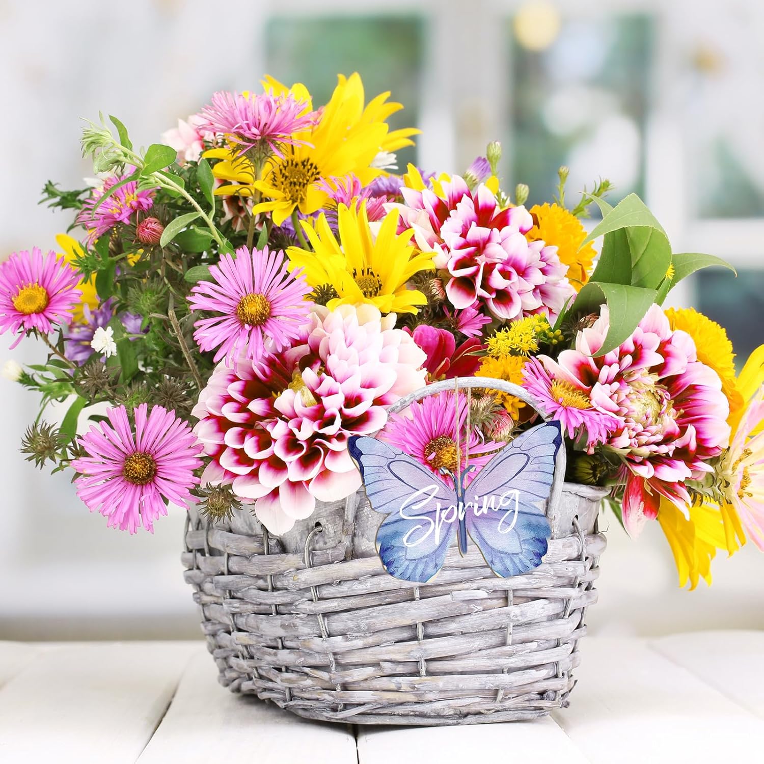 Basket of colorful flowers with a butterfly decoration on a blurred background