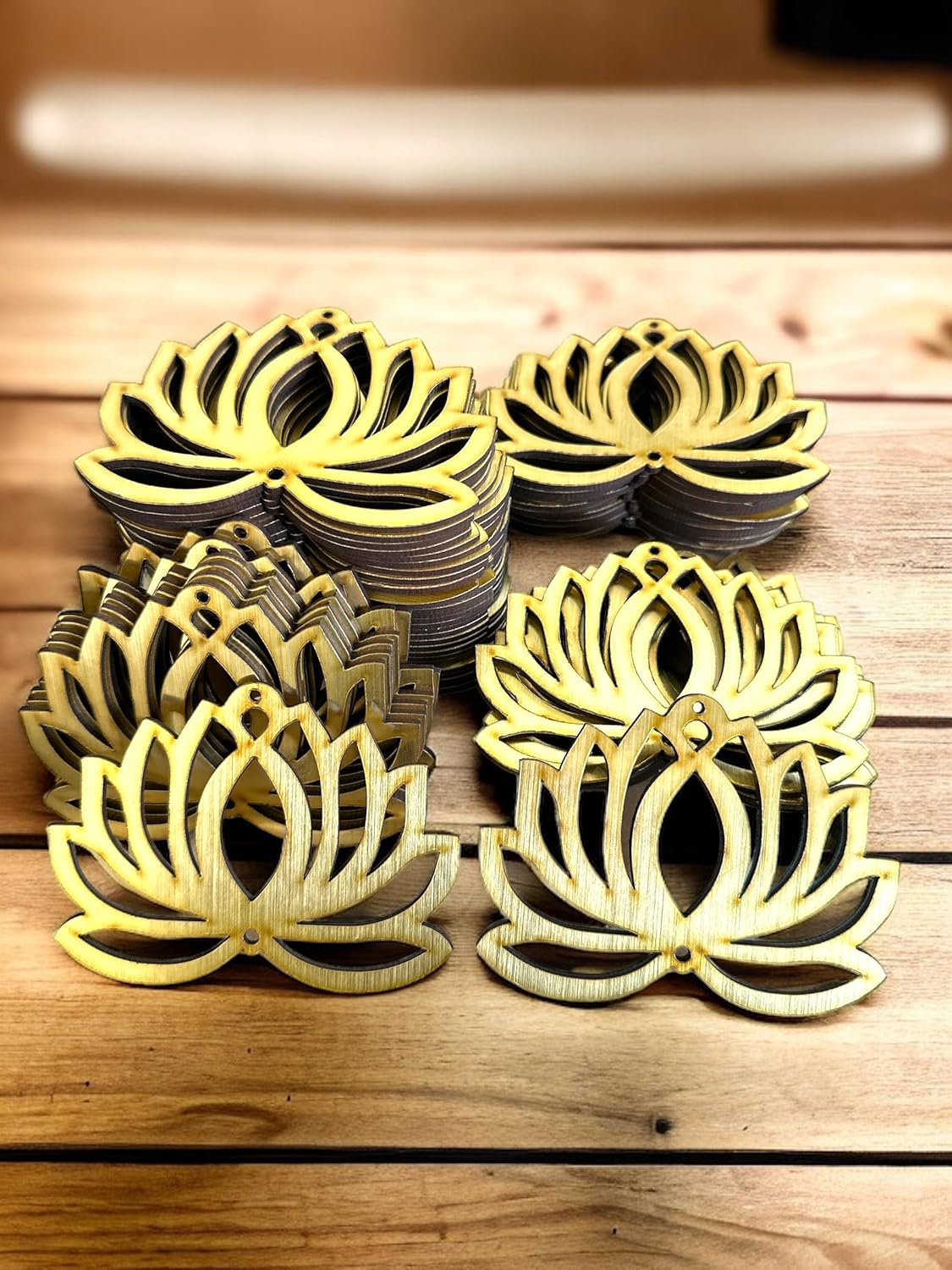 Decorative metal lotus flower coasters on a wooden surface