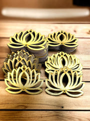 Decorative metal lotus flower coasters on a wooden surface