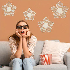 Woman wearing 3D glasses and holding popcorn on a couch with decorative wall flowers.