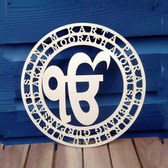 Decorative metal plate with cut-out design and text on a blue wooden background