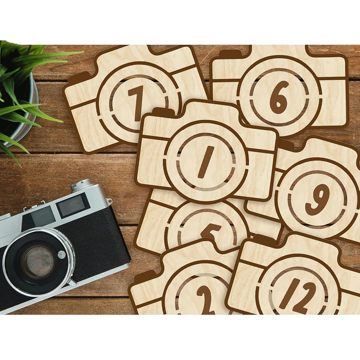 Wooden camera-shaped numbers on a wooden surface with an old camera.