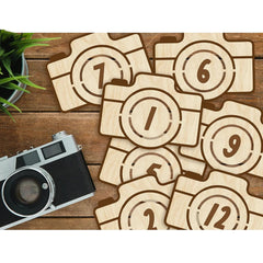 Wooden camera-shaped numbers on a wooden surface with an old camera.