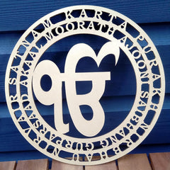 Decorative metal sign with circular design and text on a blue wooden background