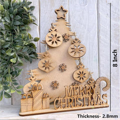 Wooden Christmas tree decoration with 'Merry Christmas' text on a light wooden background.