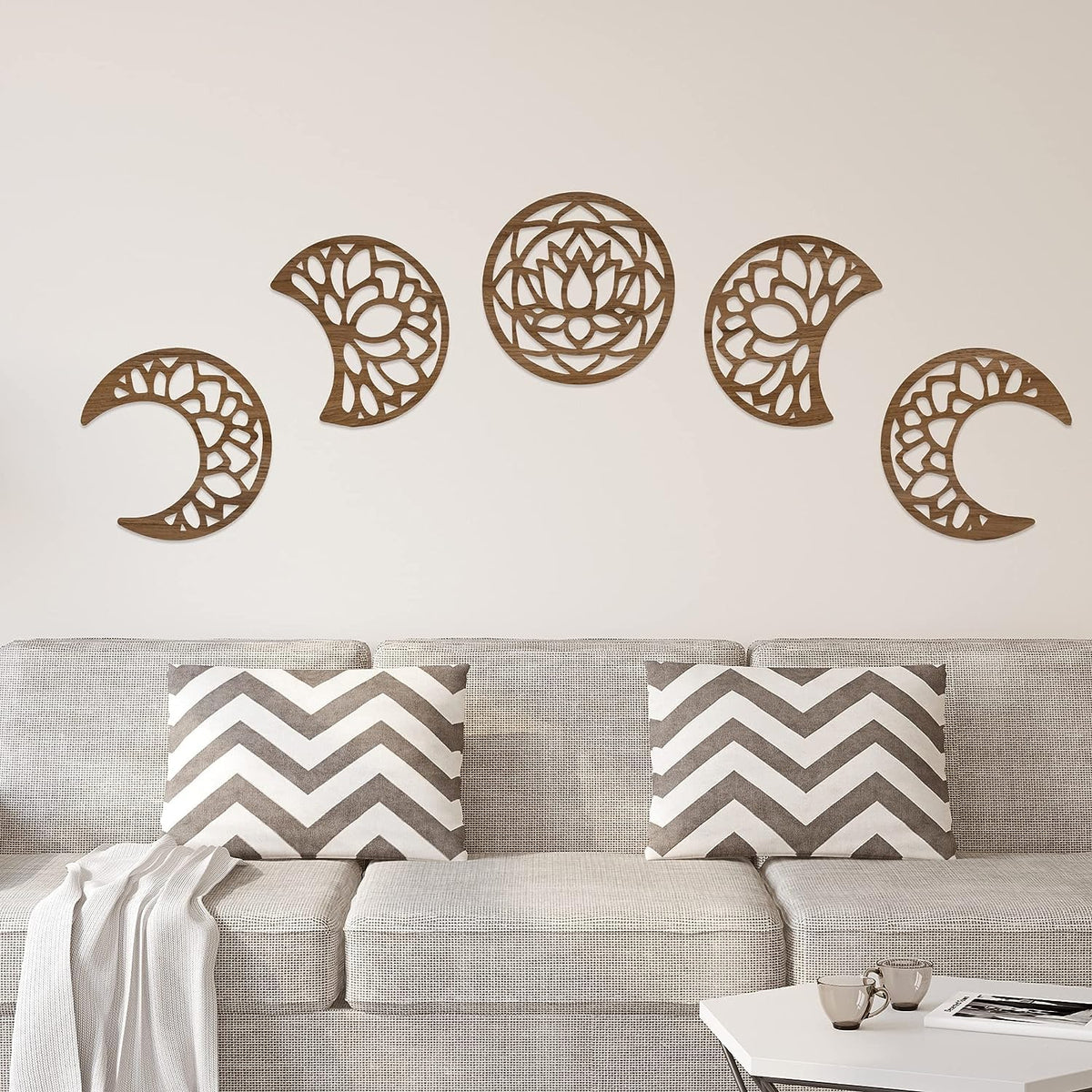 Decorative wall stickers of celestial phases on a neutral wall above a sofa with chevron patterned cushions.