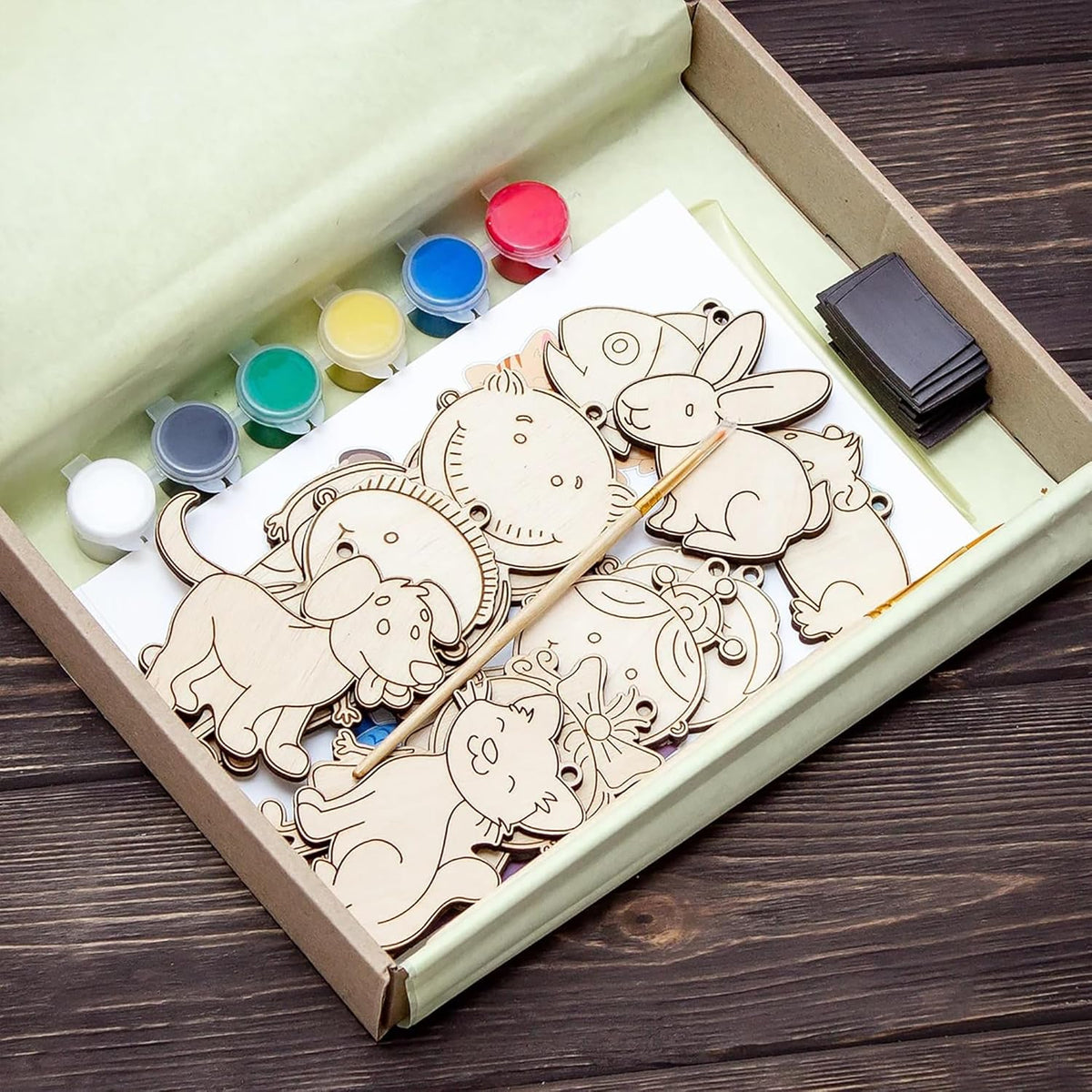 Wooden puzzle with paint and brush set in a box on a wooden surface