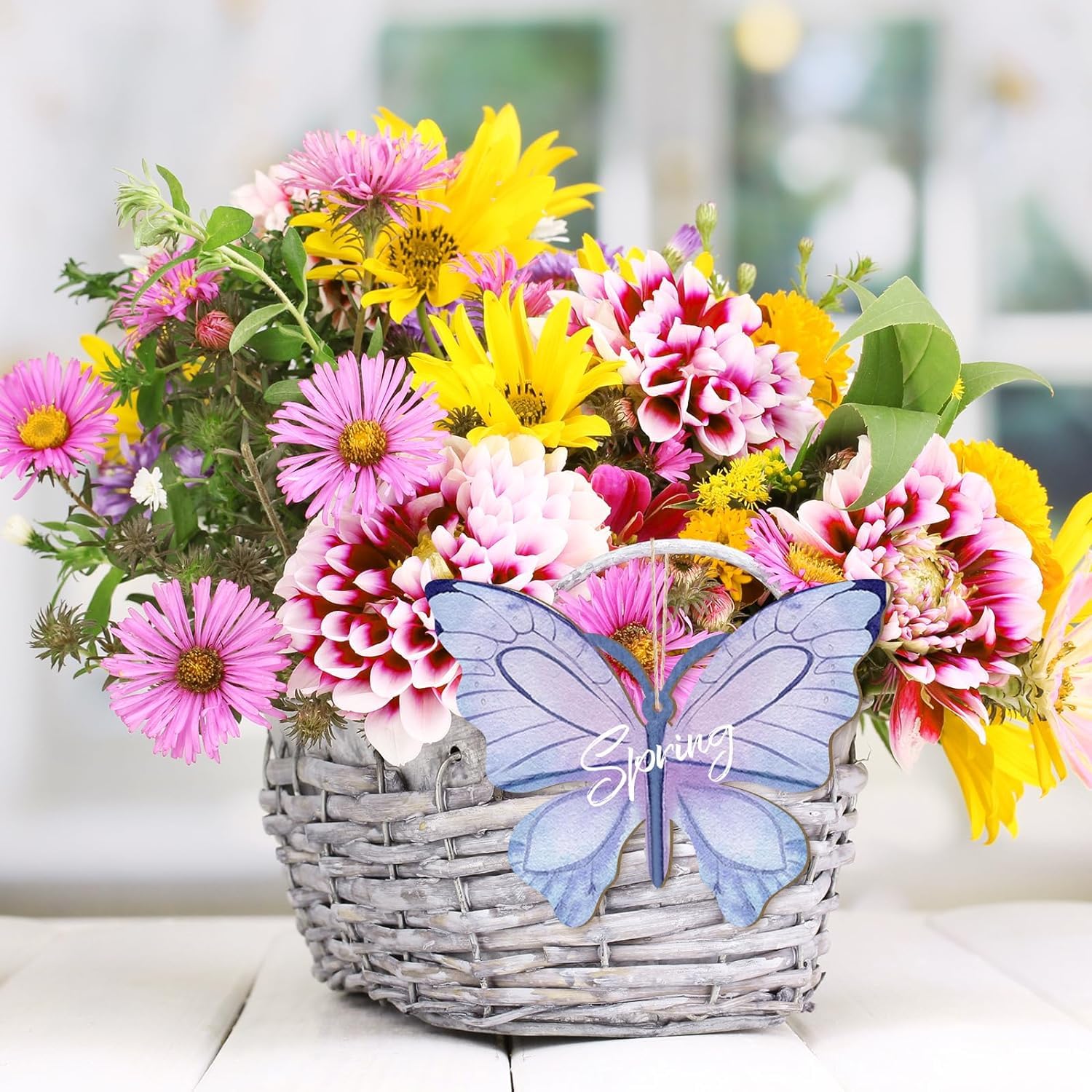 Bouquet of colorful flowers in a basket with a butterfly-shaped 'Spring' sign.