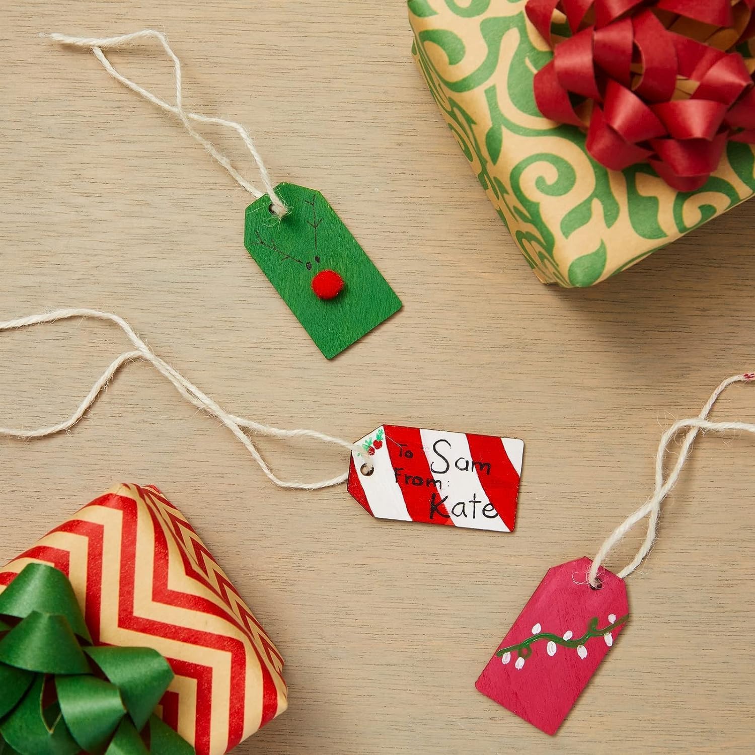 Gifts wrapped in colorful paper with decorative ribbons and tags on a wooden surface